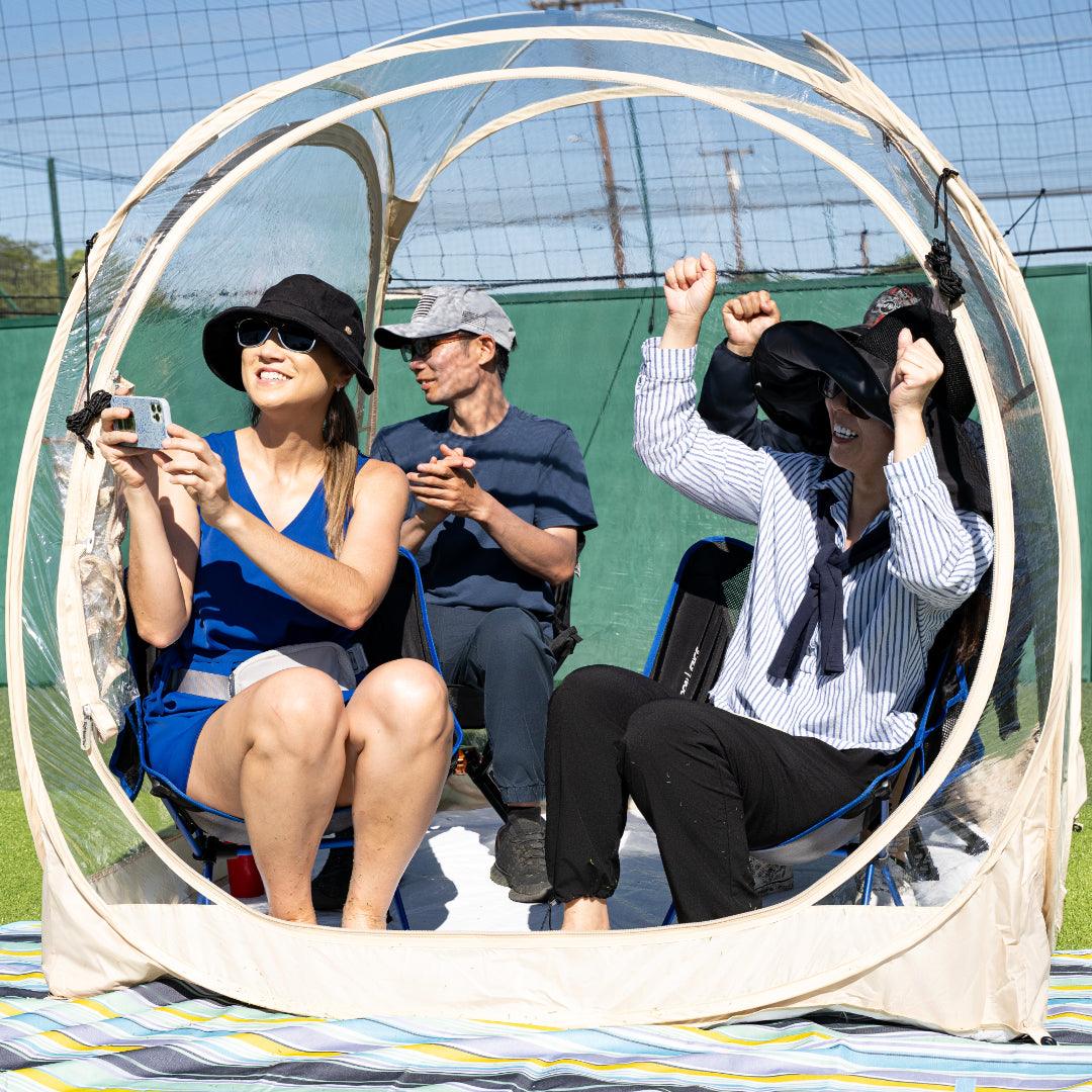 4 people cheering for the competition inside a weatherproof pod.